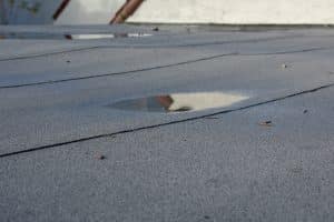 Ponding rainwater on flat roof after rain