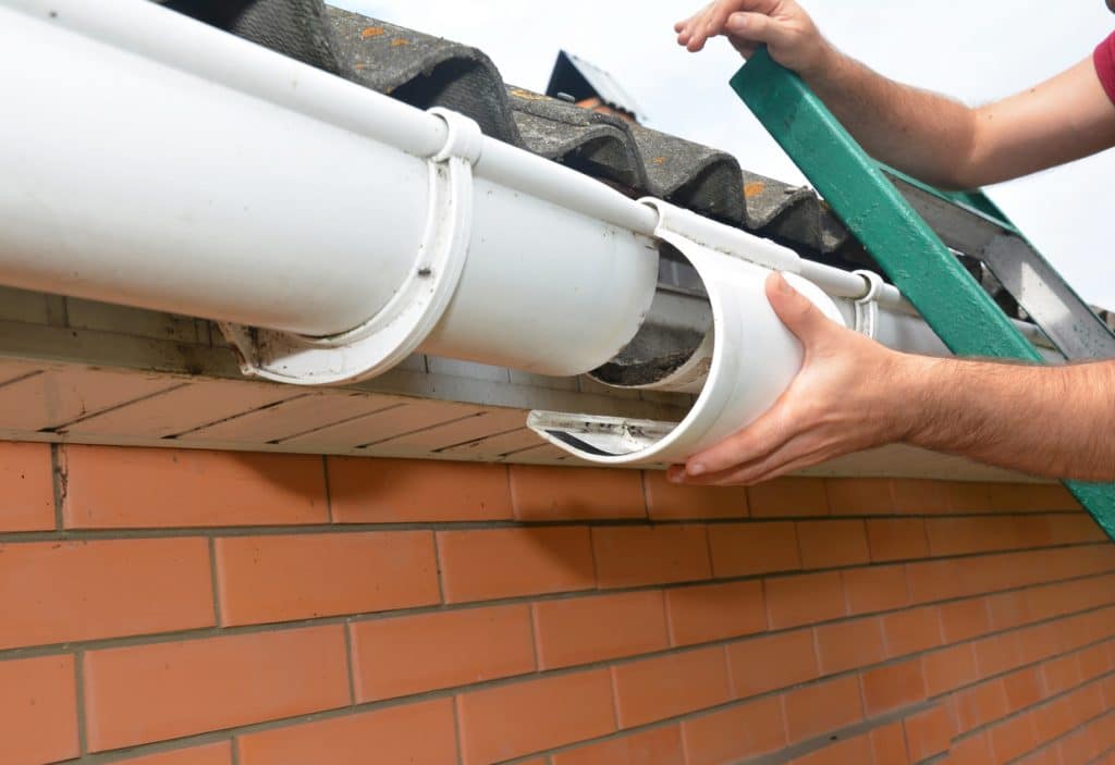 Roof gutter repair. Guttering repair. Roofer contractor repair house rain gutter pipeline.