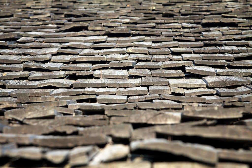 Protective cedar shake shingle on the roof being warped with age