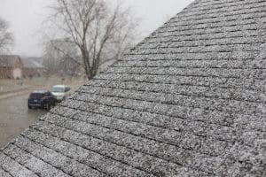 Snow on shingles on a roof of a residential home