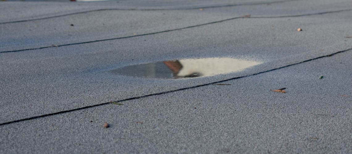 Ponding rainwater on flat roof after rain